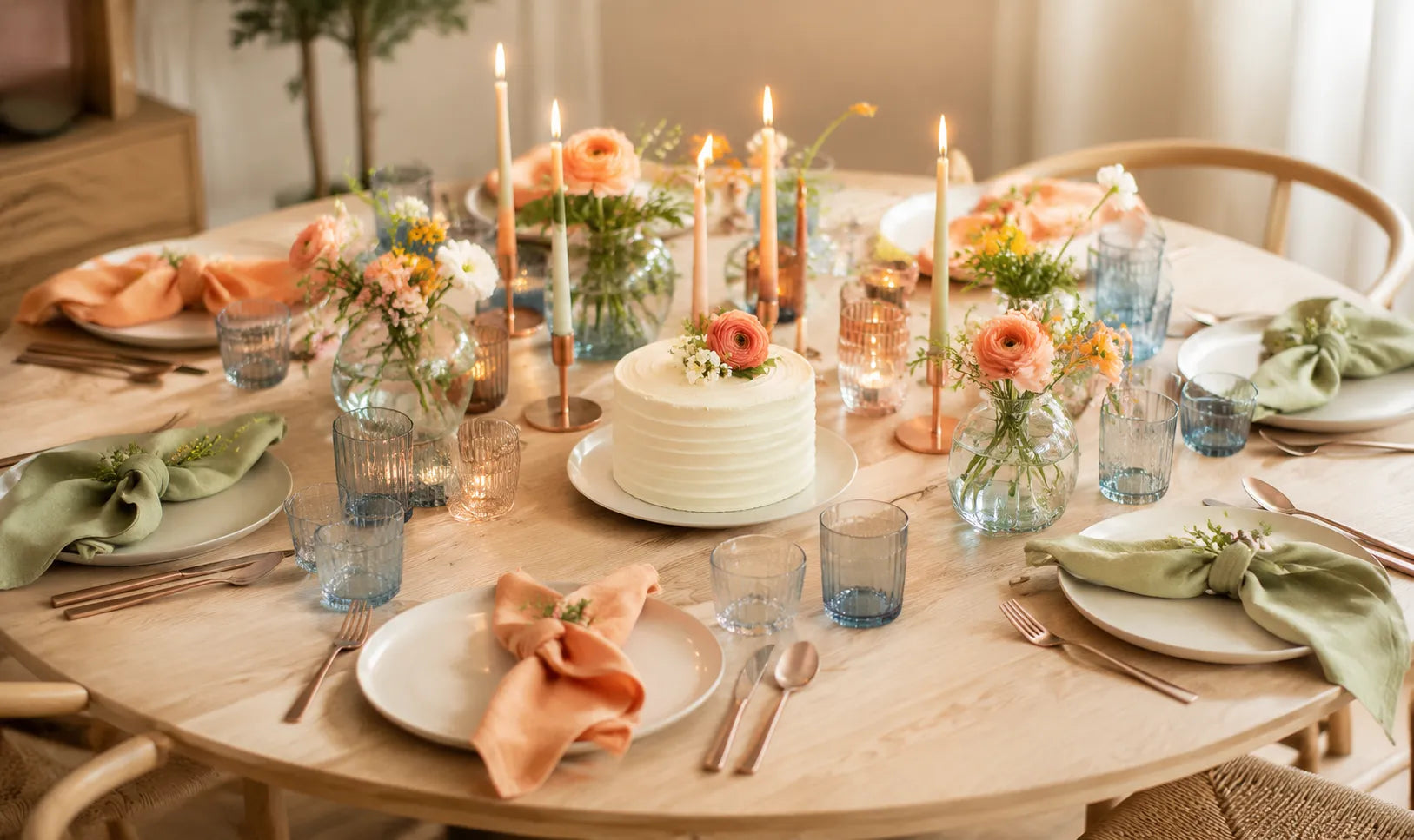 Festlich gedeckter Geburtstagstisch mit Torte, brennenden Kerzen und bunten Blumen