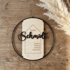 Türschild Familie aus Holz vor dunkler Holzwand