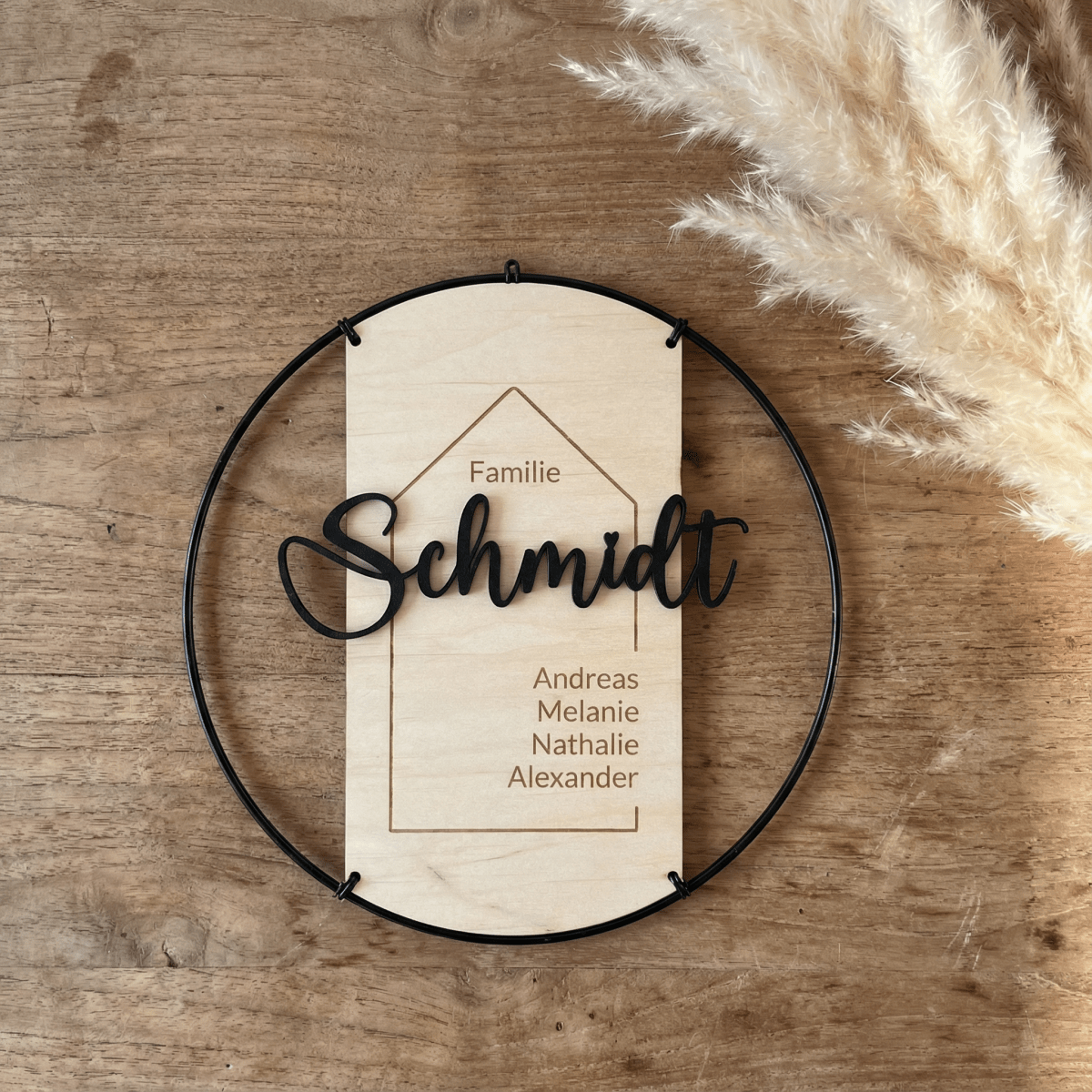 Türschild Familie aus Holz vor dunkler Holzwand