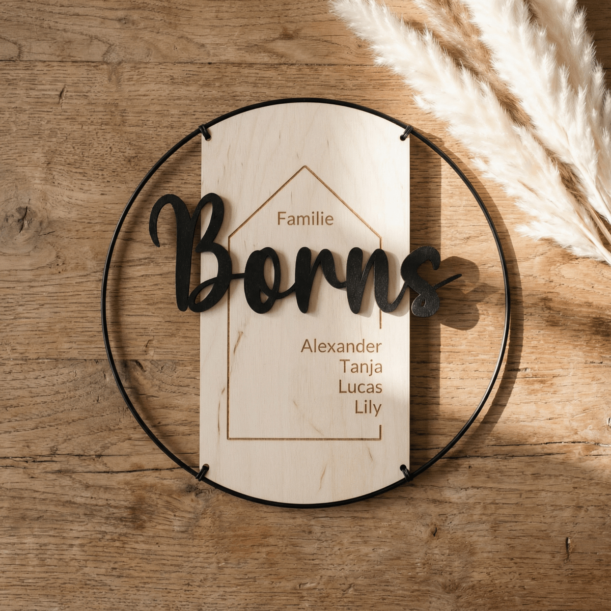 Familienschild Borns vor Holzwand mit Pampasgras