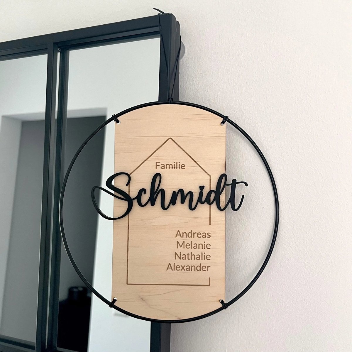 Familienschild aus Holz und Metall an der Wand neben dem Flurspiegel
