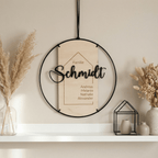 Familienschild hängend an der Wand mit Pampasgras dekoriert