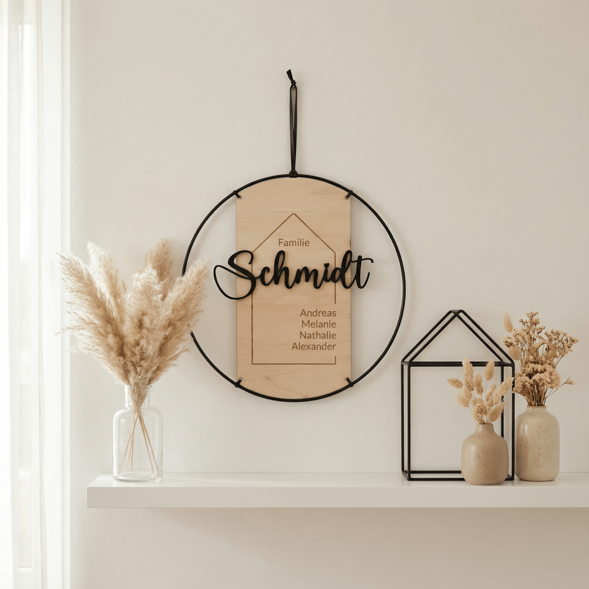 Familienschild mit Pampasgras und Deko-Haus auf hellem Regal