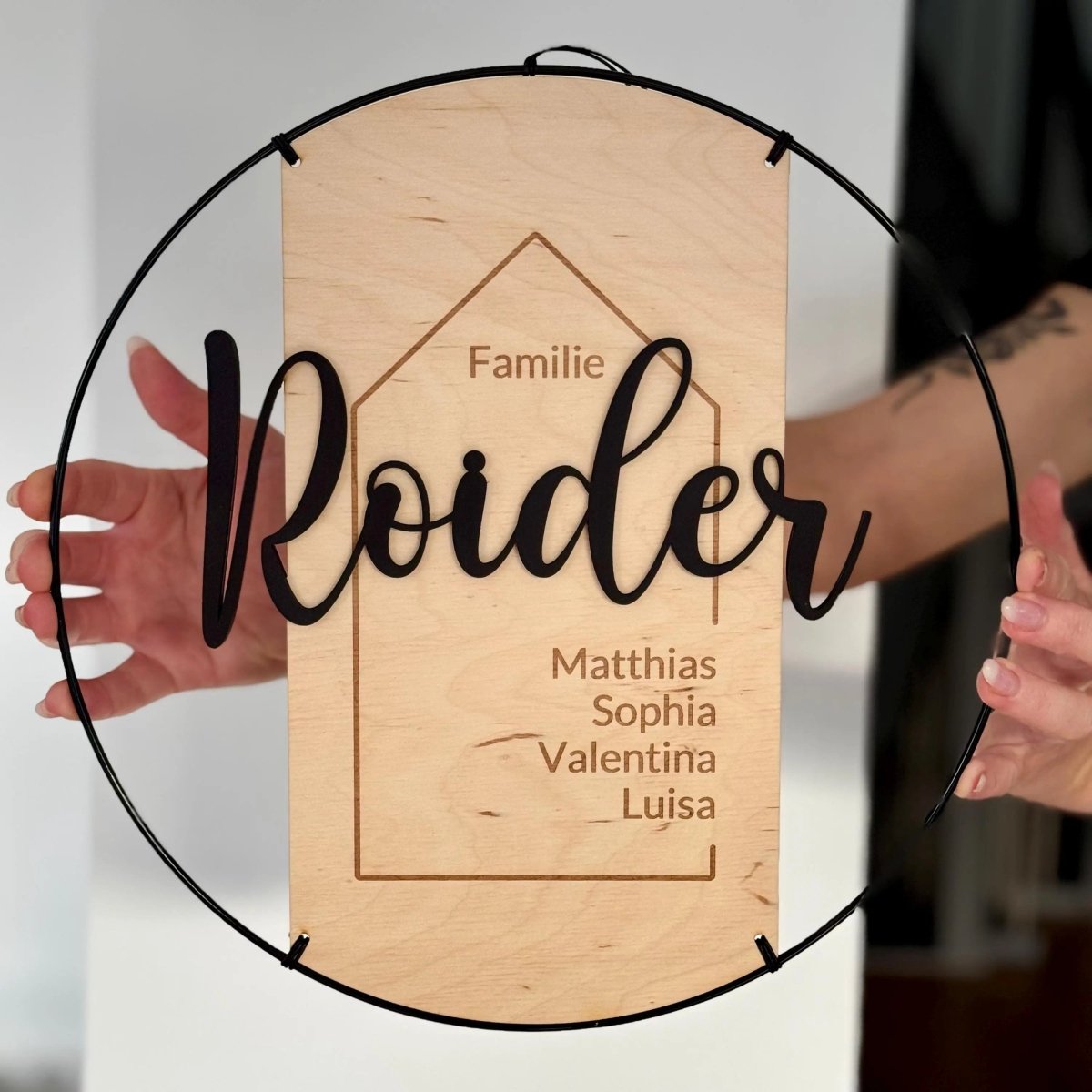 Türschild Familie Roider in Händen gehalten, Nahaufnahme der Gravur
