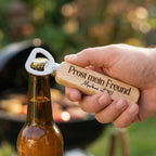 Mann öffnet Bierflasche mit dem gravierten Holz-Flaschenöffner