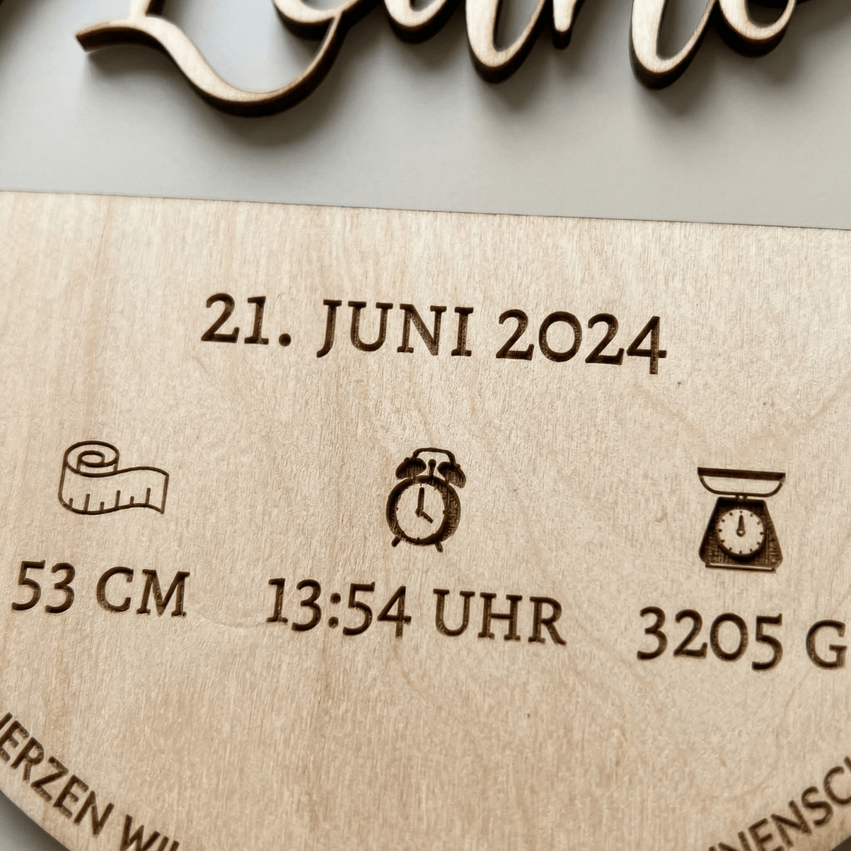 Geburtsschild aus Holz mit Name und Daten – Nahaufnahme der Holzmaserung