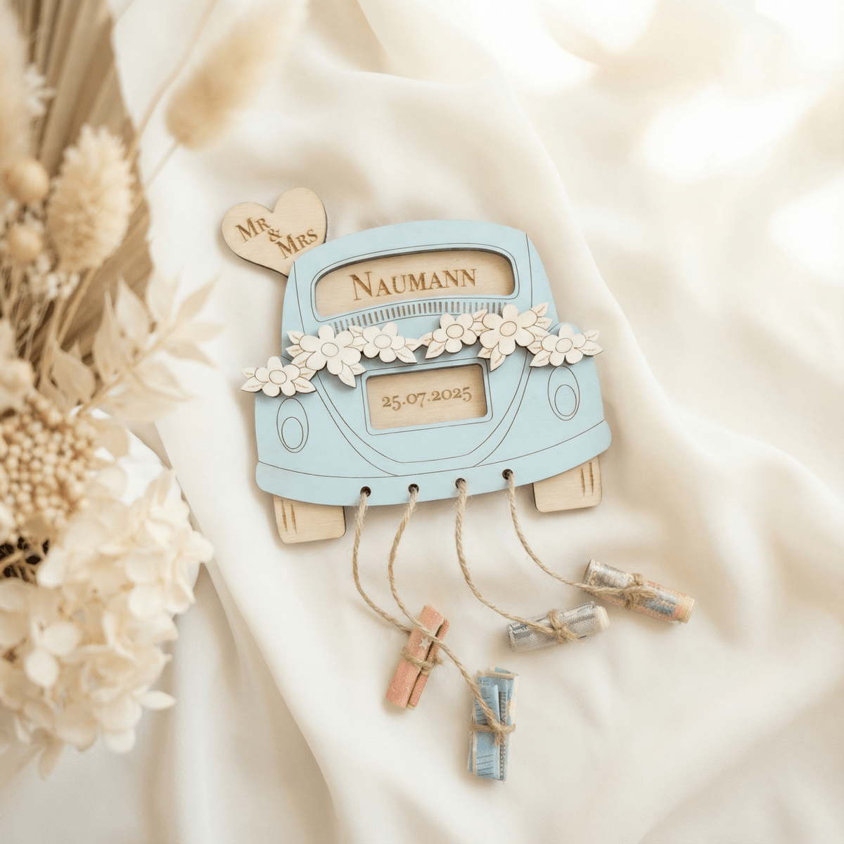 Geldgeschenk zur Hochzeit hellblau mit Namensgravur und vier Geldscheinrollen
