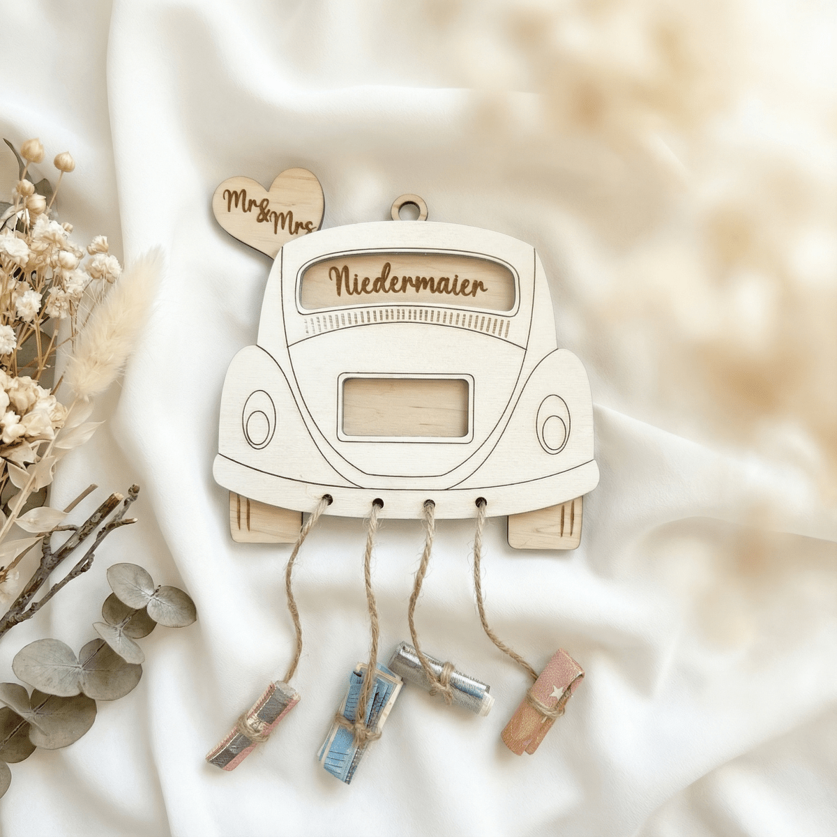 Weißes Hochzeitsauto aus Holz mit Namen, Geldrollen und Eukalyptuszweig