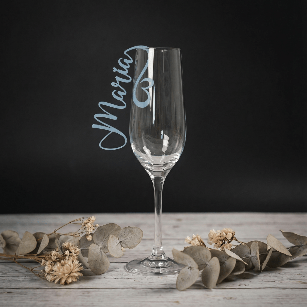 Sektglas mit Namensschild aus Holz in Hellblau am Glasstiel