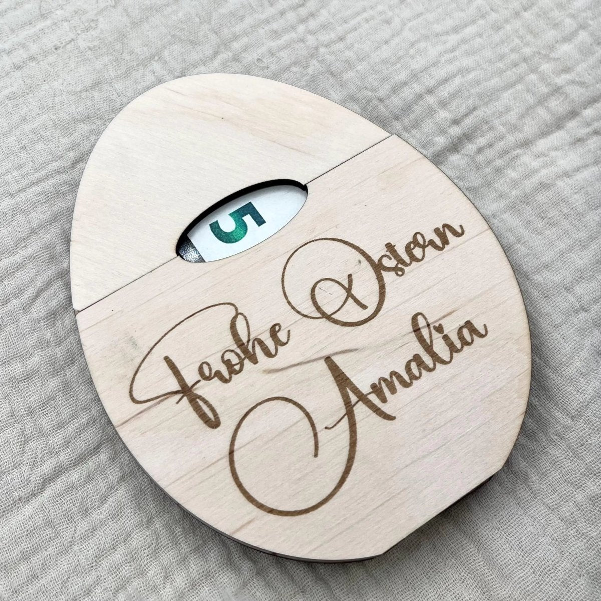 Osterei aus Holz personalisiertes Geldgeschenk – Größenvergleich in der Hand